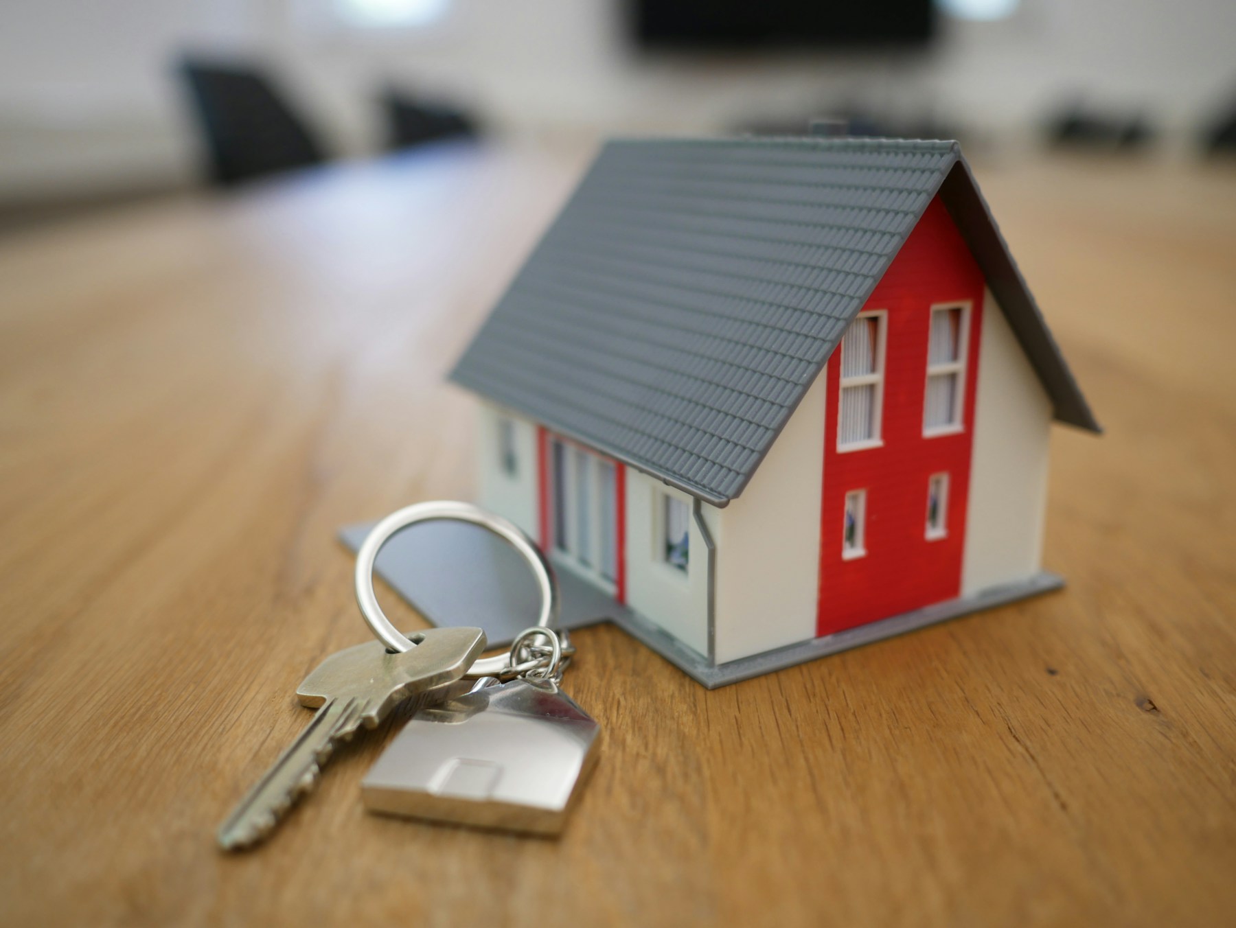 Llaves y vivienda representando una venta inmobiliaria